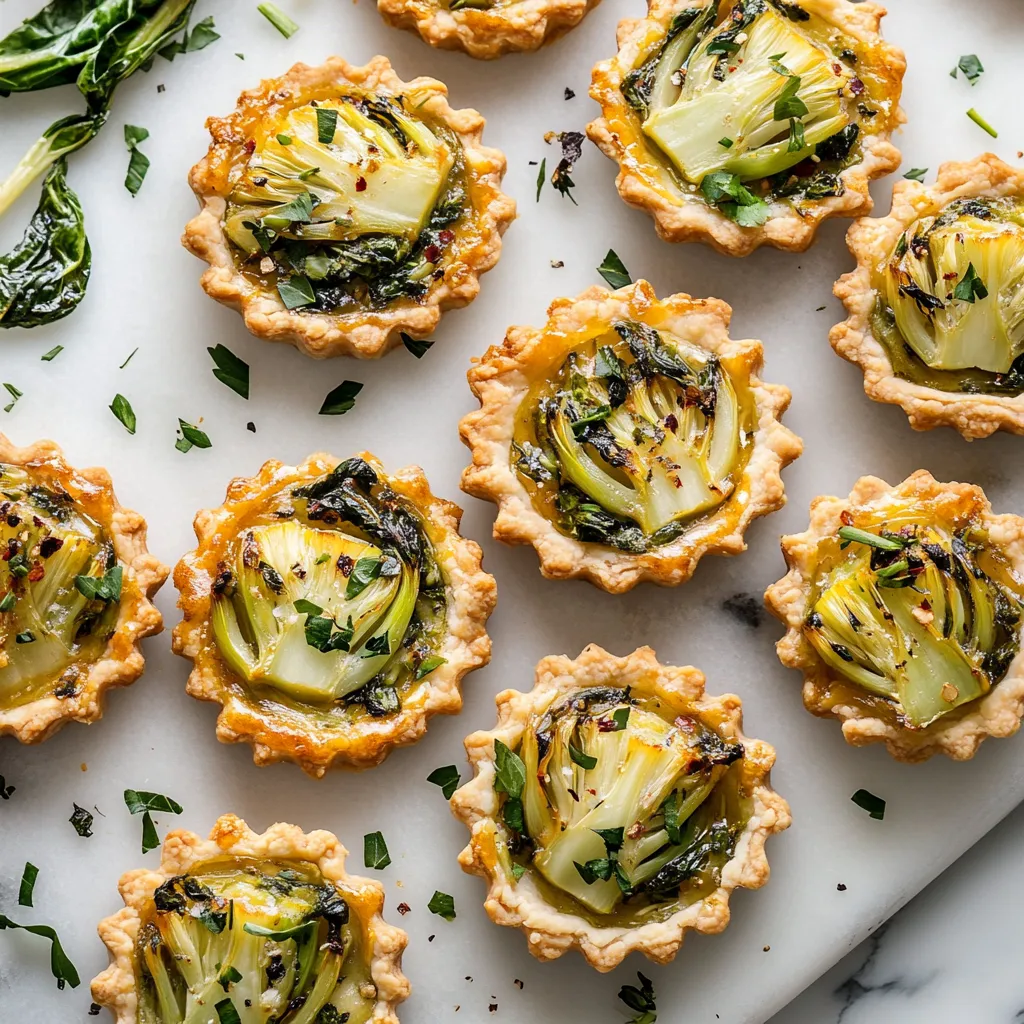 Rows of golden tartlets flecked with green herbs and set with beautifully caramelized Bok Choy, served on a marble platter. Each tartlet is a perfect love-letter between French traditions and Asian influences, just begging for a close-up snap.
