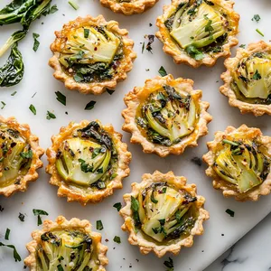 Rows of golden tartlets flecked with green herbs and set with beautifully caramelized Bok Choy, served on a marble platter. Each tartlet is a perfect love-letter between French traditions and Asian influences, just begging for a close-up snap.