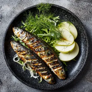 Plated on a stone dish, the bronzed, spiced mackerel boasts a charred, crispy skin. Next to it rest a sprinkle of salad, greens arranged whimsically. The thinly sliced apple and fennel add crisp whiteness and fresh contrast. A drizzle of stirring lemon-dill vinaigrette leads the eye around the plate.